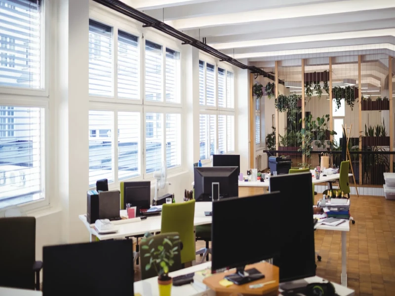 Modern coworking space with large windows covered by horizontal blinds